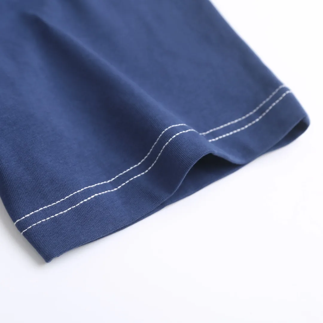 AMI Love A Embroidered Short Sleeve Fabric Selection: High-count pure cotton is selected, with moderate weight and natural drape. The cotton fiber itself has good moisture absorption and breathability, which can quickly absorb sweat and dissipate it outwards. At the same time, it feels soft and delicate, and it is non-itchy when worn next to the skin. After the pre-shrinking process, the washing shrinkage is greatly reduced, and it is not easy to deform after repeated machine washing. Craftsmanship: 1: The advanced computing system of imported embroidery machines is used to depict the contour lines of the love A pattern. White embroidery thread and Tibetan Blue fabric form a soft contrast, with neat edges, no skipping lines, and no burrs. The pattern is full and three-dimensional, and the texture is delicate. 2. Make dark embroidery of letters of the same color on the back neckline, using embroidery threads of the same color as the fabric, which is low-key and not obtrusive, and does not destroy the overall simple style. The back of the embroidered product is flat and has no bulges, and will not irritate the skin, taking into account both beauty and wearing comfort. Sewing details: 1: The collar, cuffs, hem, and shoulder lines are all made of contrasting topstitching and double-turn craftsmanship. The neatly routed threads form a sharp contrast with the Tibetan Blue fabric and outline the outline of the clothes. 2: The internal seams of the clothes are all treated with overlocking technology, without excess burrs or threads, and the details are clean and tidy; the hem and cuffs are made with double-folding stitching technology, and the edges are smooth and not frizzy to avoid curling and curling when wearing. Accessories: One-to-one customized three-standard Size: S M L XL Style No. D 292